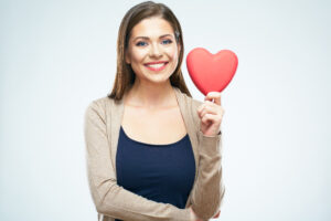 woman looking into a mirror loving her cosmetic dental treatment on her teeth